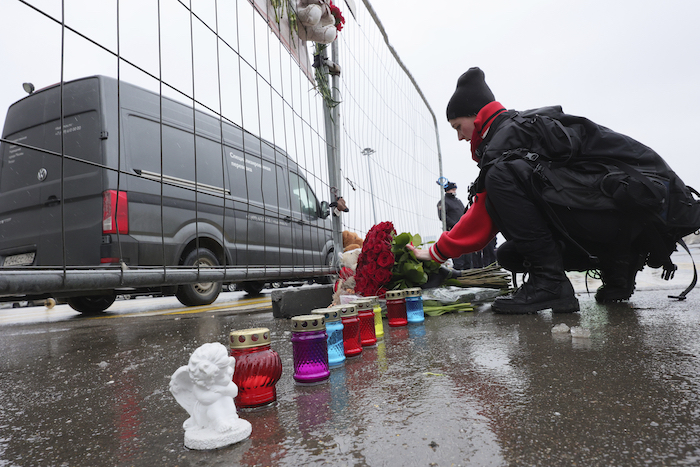 Una mujer deposita flores junto a la cerca del Crocus City Hall, una sala de conciertos de Moscú, Rusia, el 23 de marzo de 2024, un día después de un ataque que dejó varias docenas de muertos.