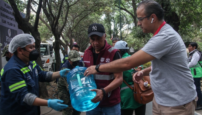 Vecinos de la Alcaldía Benito Juárez acuden al punto de agua que opera la Marina y personal del Gobierno de la Ciudad en Parque Esperanza Oteo para poder llenar garrafones. 