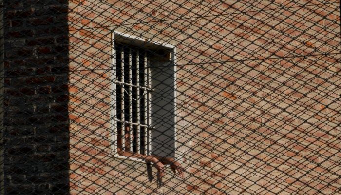 Un reo mira desde una ventana en la cárcel de Pinero, en Pinero, Argentina, el martes 9 de abril de 2024. Las autoridades han incrementado las redadas en penales, confiscado miles de celulares de contrabando y restringido las visitas. 