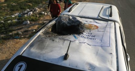 Palestinos inspeccionan un vehículo con el logotipo de World Central Kitchen alcanzado por un ataque aéreo israelí en Deir al Balah, Franja de Gaza, el martes 2 de abril de 2024.