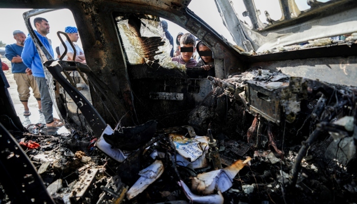 Gente inspecciona el lugar donde murieron trabajadores de World Central Kitchen en Deir al-Balah, Franja de Gaza, el martes 2 de abril de 2024. Un aparente ataque israelí mató a seis cooperantes internacionales de World Central Kitchen y a su conductor palestino, según indicó el grupo de ayuda el martes.