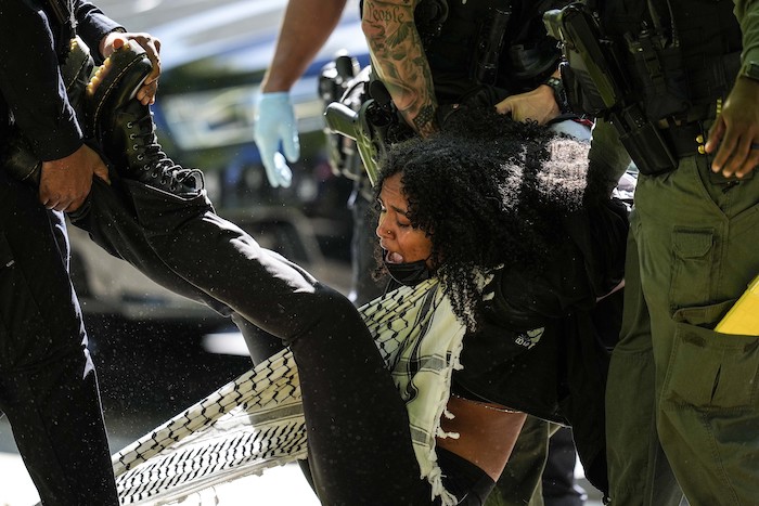 Autoridades detienen a una manifestante en el campus de la Universidad Emory durante una manifestación propalestina, el jueves 25 de abril de 2024, en Atlanta.