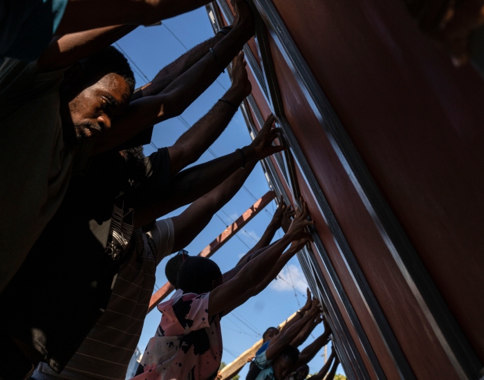 Vecinos levantan una puerta de metal para colocarla como barricada contra las pandillas en el vecindario de Petion-Ville, en Puerto Príncipe, Haití, el sábado 20 de abril de 2024. 