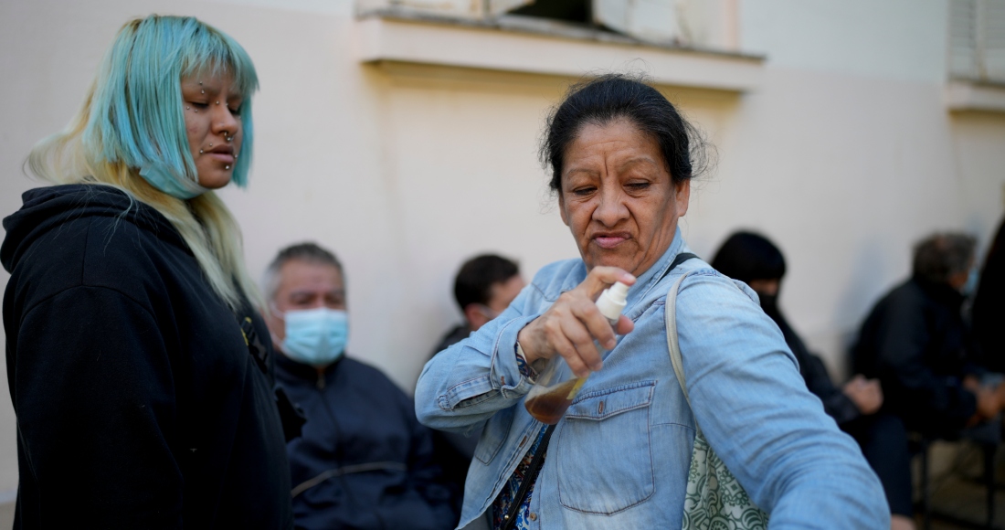 Una mujer se aplica un repelente casero contra mosquitos hecho con vainilla y agua mientras espera a ser atendida en un hospital en medio de un aumento en los casos de dengue, en Buenos Aires, Argentina, el viernes 5 de abril de 2024.