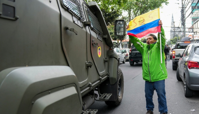 Un partidario del exvicepresidente ecuatoriano Jorge Glas protesta mientras un vehículo militar lo transporta desde el centro de detención en el que estuvo detenido tras su arresto en la Embajada de México en Quito, Ecuador, el sábado 6 de abril de 2024. Glas, quien ocupó la Vicepresidencia de Ecuador entre 2013 y 2018, fue condenado por corrupción y se encontraba refugiado en la Embajada desde diciembre.