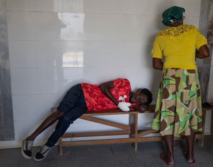 Marc Baptiste descansa en un banco tras ser atendido en una sala de urgencias de Médicos Sin Fronteras en el vecindario de Cite Soleil en Puerto Príncipe, el viernes 19 de abril de 2024.