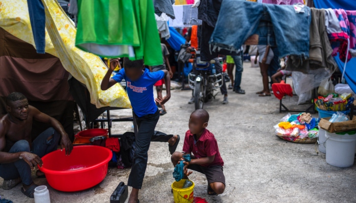 Un niño lava ropa en una escuela pública que sirve de refugio para personas desplazadas de sus hogares debido a los enfrentamientos entre pandillas en Puerto Príncipe, Haití, el lunes 22 de abril de 2024. 