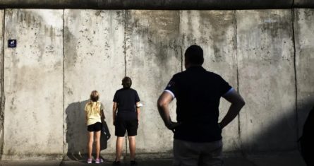 Visitantes contemplan los restos del Muro de Berlín en el monumento en la Bernauer Strasse en vísperas del 60 aniversario del inicio de la construcción, 12 de agosto de 2021.