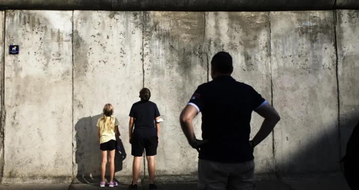 Visitantes contemplan los restos del Muro de Berlín en el monumento en la Bernauer Strasse en vísperas del 60 aniversario del inicio de la construcción, 12 de agosto de 2021. 