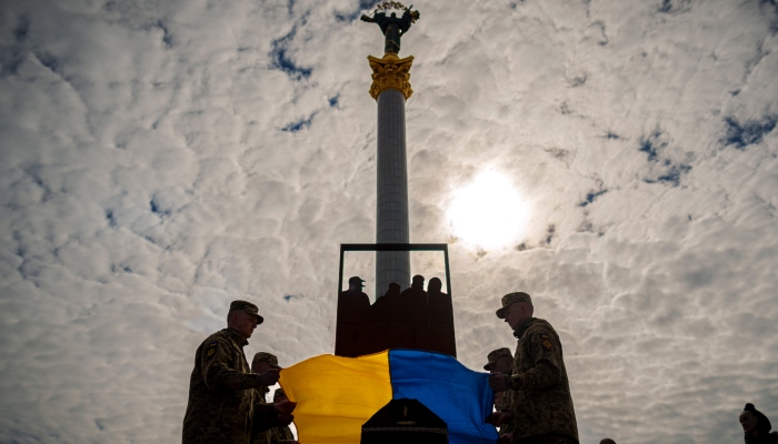 Soldados ucranianos colocan la Bandera de su país en el ataúd de su compañero caído Vadym Popelniuk, durante su funeral en la Plaza Independencia de Kiev, Ucrania, el viernes 5 de abril de 2024.