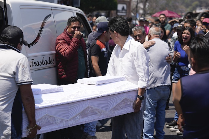 Trabajadores de la funeraria cargan el ataúd con los restos de de una niña de ocho años, en Taxco, México, el jueves 28 de marzo de 2024.