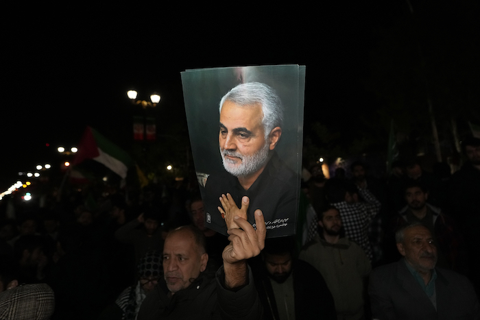 Un manifestante sostiene un cartel del fallecido General de la Guardia Revolucionaria iraní Qassem Soleimani, asesinado en un ataque de dron estadounidense en 2020 en Irak, en un acto contra Israel ante la Embajada británica en Teherán, Irán, la madruga del domingo 14 de abril de 2024.