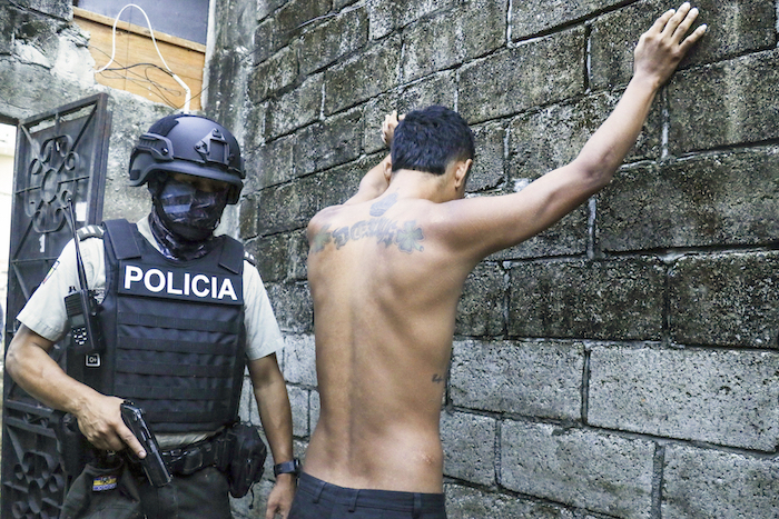 Un residente apoya las manos en un muro mientras la policía le registra para buscar armas o drogas, dentro de una operación contra grupos criminales en Guayaquil, Ecuador, el 4 de abril de 2024.