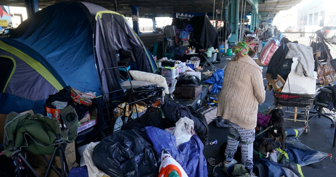 Una mujer recoge sus pertenencias antes de las tareas de retiro de un campamento de desamparados en San Francisco, el 29 de agosto de 2023.