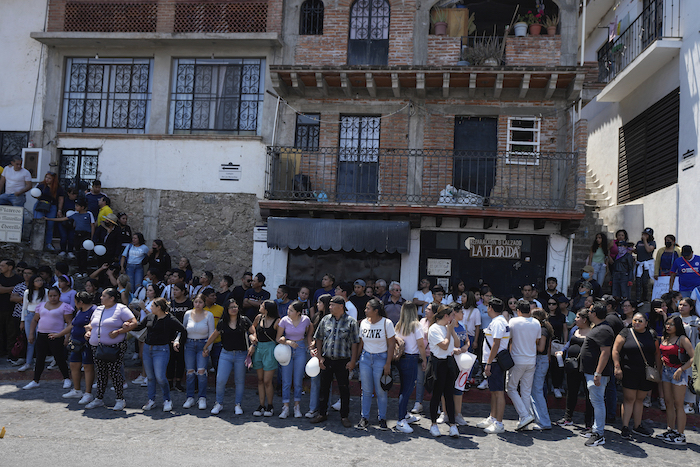 Varios vecinos en la calle en el momento en que el ataúd con los restos de una niña de ocho años es entregado a sus familiares en Taxco, México, el jueves 28 de marzo de 2024.