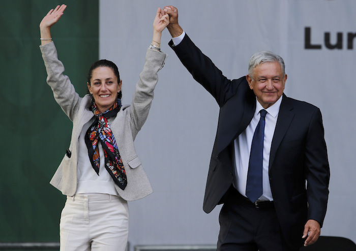 En esta imagen de archivo, el Presidente de México, Andrés Manuel López Obrador (derecha), y la entonces Jefa de Gobierno de la Ciudad de México, Claudia Sheinbaum, saludan a sus partidarios en un mitin en la principal plaza de la capital, el Zócalo, el 1 de julio de 2019.