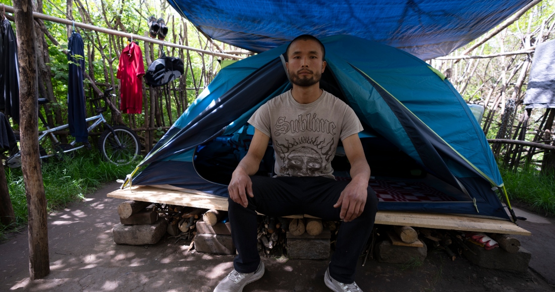 Chen Wang, un migrante chino que se encuentra actualmente sin hogar en Nueva York, posa para una foto delante de su casa de campaña el viernes 3 de mayo de 2024.