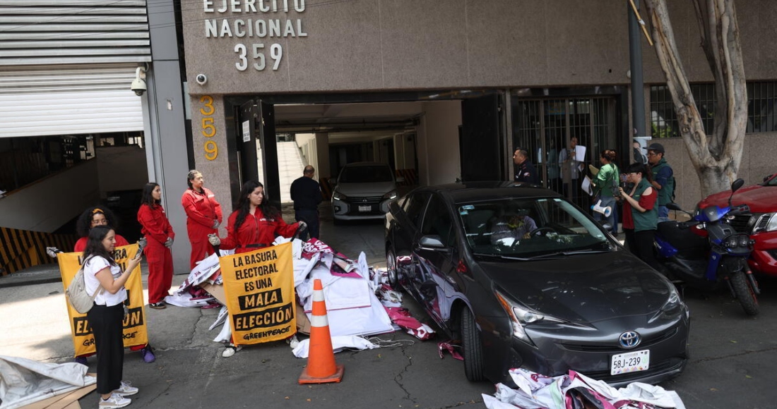 Personal de seguridad retira la propaganda electoral que activistas de Greenpeace México devolvieron en la sede del Partido Morena en la Ciudad de México. 