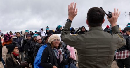 La peruana Julia Paredes, a la izquierda con un gorro blanco, escucha las instrucciones de un agente de la patrulla fronteriza junto a otros solicitantes de asilo, mientras esperan a ser procesados tras cruzar la cercana frontera con México, el jueves 25 de abril de 2024, en Boulevard, California.