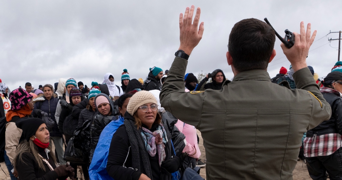 La peruana Julia Paredes, a la izquierda con un gorro blanco, escucha las instrucciones de un agente de la patrulla fronteriza junto a otros solicitantes de asilo, mientras esperan a ser procesados tras cruzar la cercana frontera con México, el jueves 25 de abril de 2024, en Boulevard, California.