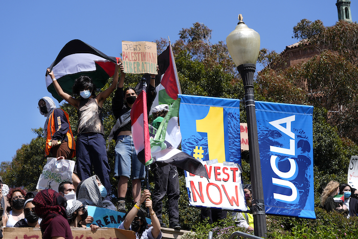 Manifestantes muestran pancartas y ondean banderas en el campus de la Universidad de California en Los Ángeles después de enfrentamientos nocturnos entre grupos propalestinos y proisraelíes, el miércoles 1 de mayo de 2024, en Los Ángeles.