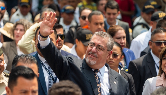 El Presidente guatemalteco Bernardo Arévalo saluda mientras se dirige de Palacio Nacional al Congreso, rodeado por su personal y guardias de seguridad, en Ciudad de Guatemala, el lunes 6 de mayo de 2024. 