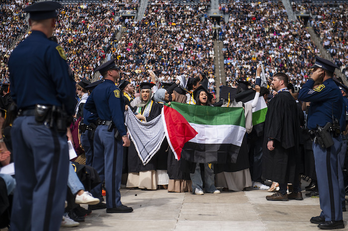 Rawan Antar, de 21 años (centro), grita consignas en apoyo a los palestinos durante la ceremonia de graduación de la Universidad de Michigan, el sábado 4 de mayo de 2024, en Ann Arbor, Michigan.