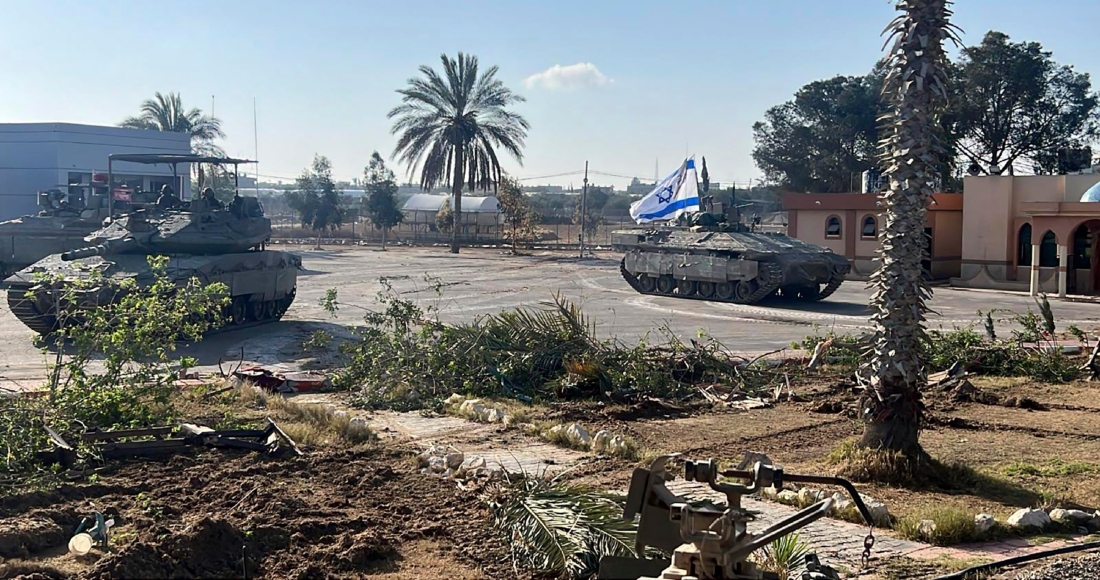 En esta imagen, proporcionada por las Fuerzas de Defensa de Israel, un tanque con una bandera israelí entra al lado gazatí del paso fronterizo de Rafah, el 7 de mayo de 2024.