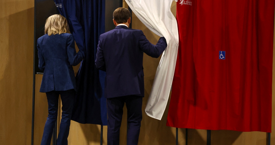 El Presidente francés Emmanuel Macron y su esposa Brigitte Macron entran en una cabina de votación durante las elecciones europeas, el domingo 9 de junio de 2024 en Le Touquet-Paris-Plage, al norte de Francia.