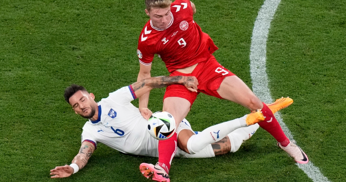 Rasmus Hojlund (derecha), de la selección de Dinamarca, y Nemanja Gudelj, de Serbia, disputan un balón durante el partido de la Eurocopa realizado el martes 25 de junio de 2024. 