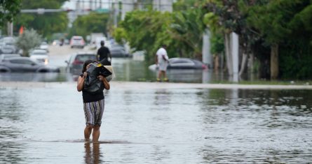 Una mujer camina por una calle inundada en el noreste del condado de Miami-Dade, Florida, el jueves 13 de junio de 2024.