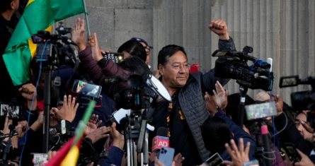 El Presidente boliviano Luis Arce levanta un puño cerrado rodeado de partidarios y medios de comunicación frente al Palacio de Gobierno en La Paz, Bolivia, el miércoles 26 de junio de 2024.