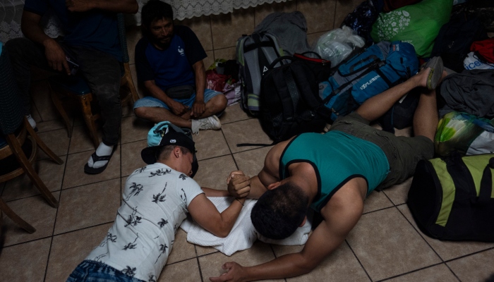 Yazmani Gomes, a la izquierda, echa un pulso con Eliseo López mientras esperan a cenar en el refugio para migrantes San Juan Bosco en Nogales, México, el martes 25 de junio de 2024. Muchos migrantes que no logran pasar el filtro son deportados a Nogales, una amplia ciudad en el lado mexicano del estado de Sonora, y terminan en el San Juan Bosco, donde un enorme ventilador en una antigua capilla ofrece alivio del sofocante calor estival.