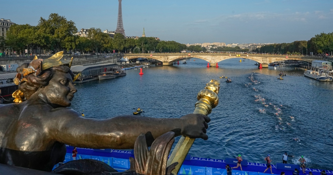 En esta imagen de archivo, deportistas se lanzan a nadar en el río Sena desde el puente Alejandro III en la primera manga de la prueba preolímpica de triatlón femenino, en París, el 17 de agosto de 2023.