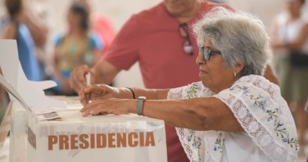 Una persona deposita su voto en la urna de la elección presidencial.