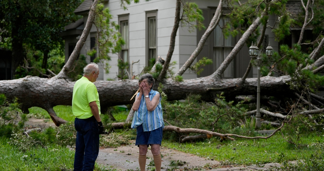 Jackie Jecmenek, a la derecha, habla con Bobby Head, un trabajador de la ciudad, frente a la casa de su vecino tras el paso de Beryl, el lunes 8 de julio de 2024, en Bay City, Texas. 