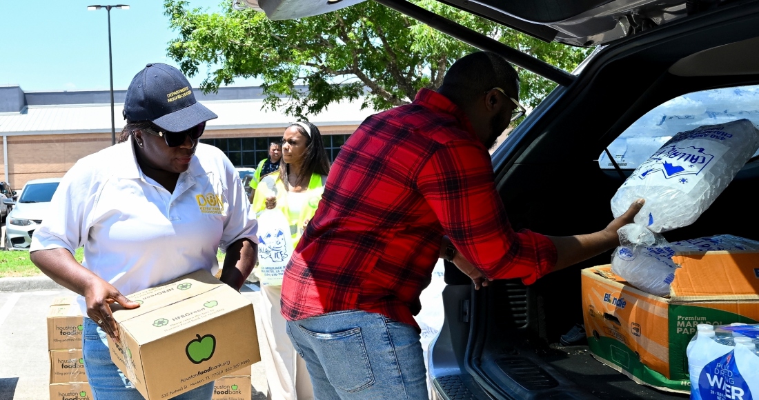 Voluntarios ayudan a entrega hielo y suministros en el centro de refresco Acres Homes en Houston, el miércoles 10 de julio de 2024, después de que el huracán Beryl golpeara la ciudad y dejara casi 3 millones de casas y negocios sin luz..