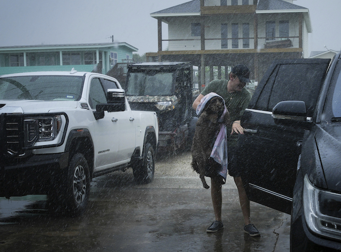 Blake Braunsube a su perra Dolly en el vehículo de su familia mientras las bandas exteriores de la tormenta "Beryl" comienzan a llegar a la costa el domingo 7 de julio de 2024 en Port O'Connor, Texas.