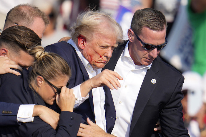 El expresidente y virtual candidato presidencial republicano, Donald Trump, recibe ayuda para bajar del estrado en un mitin de campaña en Butler, Pensilvania, el sábado 13 de julio de 2024.