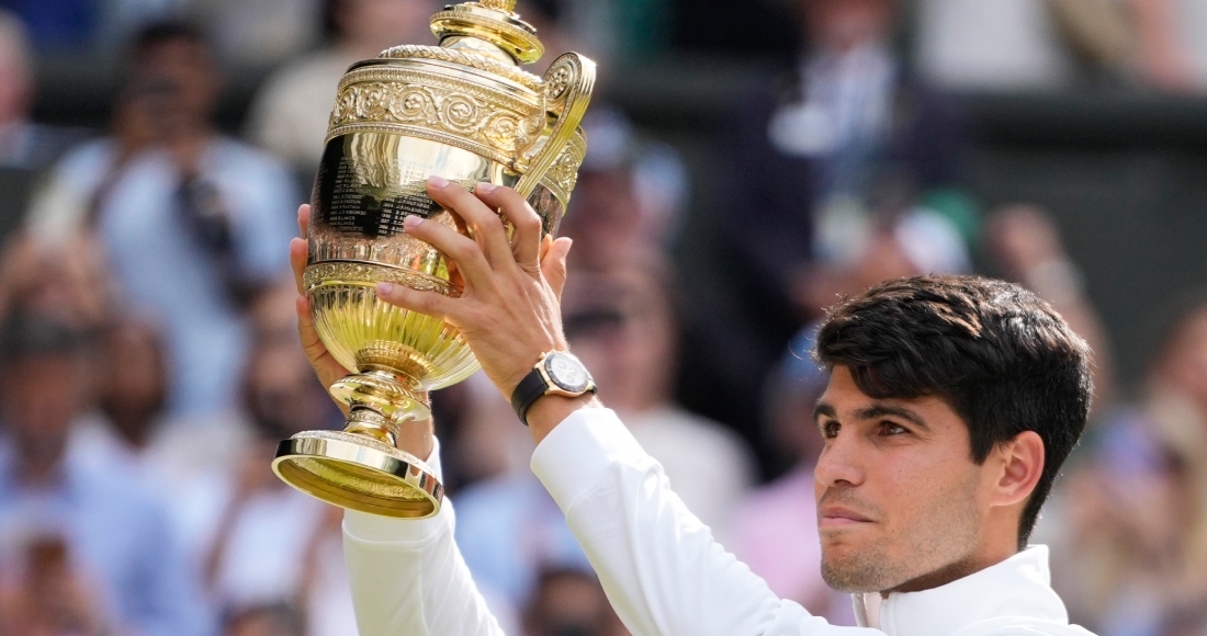 El español Carlos Alcaraz sostiene el trofeo al vencer en la final de Wimbledon a Novak Djokovic el domingo 14 de julio del 2024.