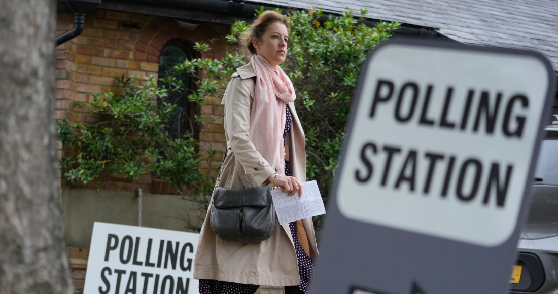 Una mujer sostiene su tarjeta de votación mientras llega a votar en Londres en las elecciones locales, el jueves 2 de mayo de 2024.