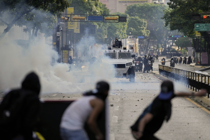 Manifestantes se enfrentan a la policía en las protestas contra los resultados de las elecciones que dieron por ganador a Nicolás Maduro, el día después de las votaciones en Caracas, Venezuela, el lunes 29 de julio de 2024.