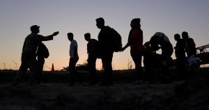 Migrantes que cruzaron el río Grande (Bravo) y entraron a Estados Unidos desde México forman una fila para ser procesados por la Oficina de Aduanas y Protección Fronteriza de Estados Unidos, el 23 de septiembre de 2023, en Eagle Pass, Texas.