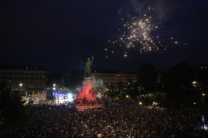 Personas lanzan fuegos artificiales al reunirse en la Plaza de la República tras la revelación de los resultados preliminares de la segunda vuelta de las elecciones legislativas, en París, Francia, el domingo 7 de julio de 2024.