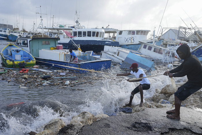 Pescadores arrastran un barco dañado por el paso del huracán "Beryl" para amarrarlo a puerto, en Bridgetown, Barbados, el 1 de julio de 2024.