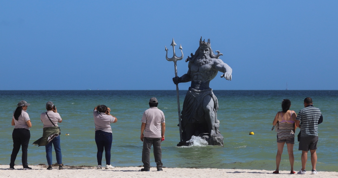 Turistas toman fotografías de la escultura de Poseidón antes de la llegada del huracán "Beryl" en Progreso, Yucatán, México, el 4 de julio de 2024.