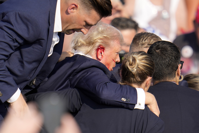 El expresidente y virtual candidato presidencial republicano, Donald Trump, recibe ayuda para bajar del estrado en un mitin de campaña en Butler, Pensilvania, el sábado 13 de julio de 2024.