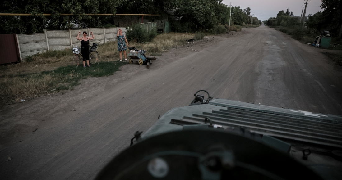 En esta imagen proporcionada por el servicio de prensa de la 24ta Brigada Mecanizada de Ucrania, residentes locales saludan a soldados ucranianos cerca de Chasiv Yar, en la región de Donetsk, Ucrania, el sábado 17 de agosto de 2024.