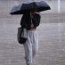 Una mujer se protege de la lluvia mientras camina por el pasillo central del Monumento a la Revolución en la Ciudad de México.