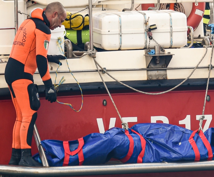 Buzos del cuerpo de bomberos de Italia suben a bordo una bolsa de plástico con el cuerpo de una de las víctimas de un naufragio en Porticello, Sicilia, en el sur de Italia, el jueves 22 de agosto de 2024. 